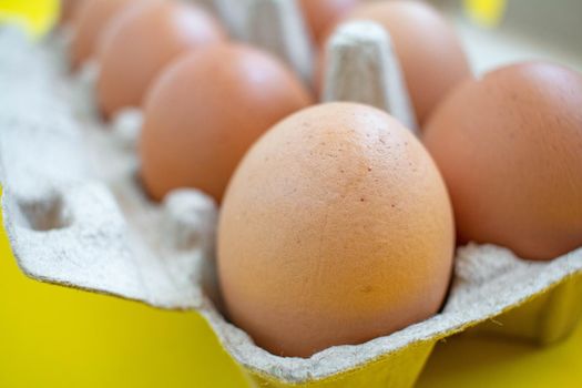 Closeup brown eggs in paper box A box full of eggs Bought from supermarket placed on a yellow background