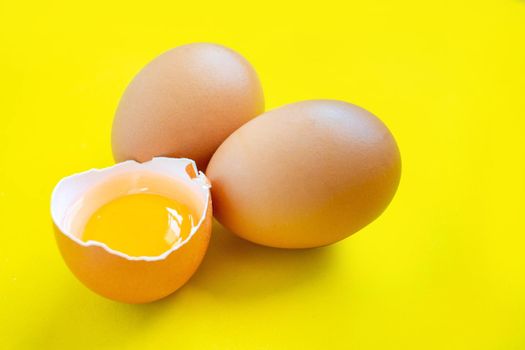 Closeup cracked brown eggs Buy from supermarket Placed on a yellow background.