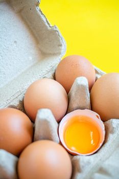 Closeup cracked brown eggs Arranged in a paper box Buy from supermarket Placed on a yellow background