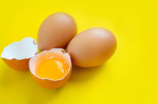 Closeup cracked brown eggs Buy from supermarket Placed on a yellow background.