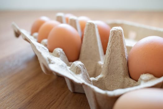 Closeup brown eggs in paper box There is not a full box of eggs. Buy from the supermarket, put it on the wooden floor.