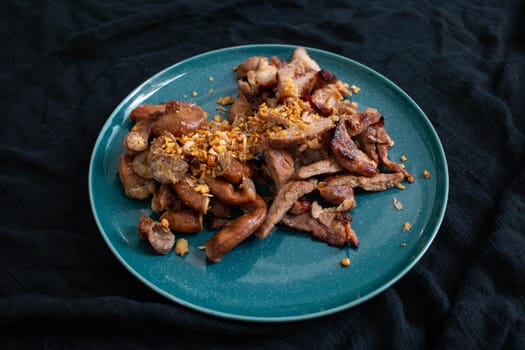 Grilled Pork Neck and Grilled Pork Intestine. Garnish with fried garlic. Local food in Thailand It is a popular food. You can find it at street food stores.