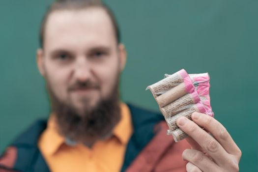 Serious Young Man Holding Firecrackers in his Hand. Bearded Guy Getting Ready for New Year Fun