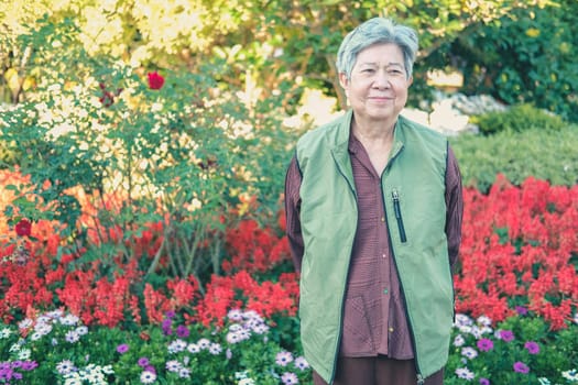 asian old elderly female elder woman resting relaxing in garden. senior leisure lifestyle