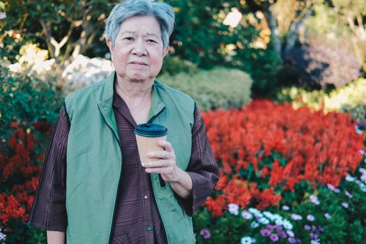 asian old elderly female elder woman drinking coffee tea in garden. senior leisure lifestyle