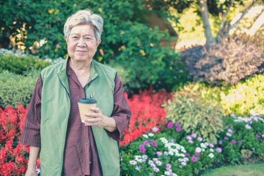 asian old elderly female elder woman drinking coffee tea in garden. senior leisure lifestyle