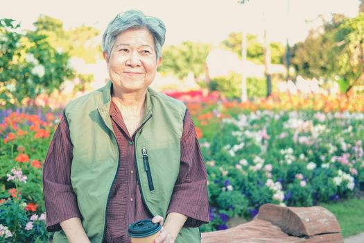 asian old elderly female elder woman drinking coffee tea in garden. senior leisure lifestyle