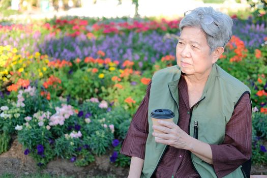 asian old elderly female elder woman drinking coffee tea in garden. senior leisure lifestyle