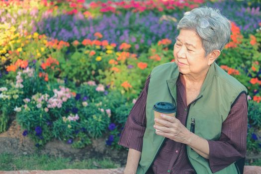 asian old elderly female elder woman drinking coffee tea in garden. senior leisure lifestyle
