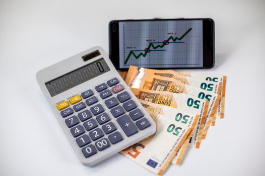 50 euro bills with calculator and graph on white background