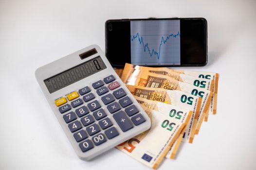 50 euro bills with calculator and graph on white background