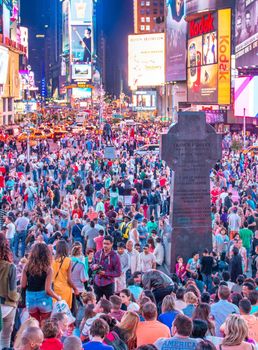 NEW YORK CITY - JUNE 11, 2013: Tourists crowded in Duffy Square at night, famous tourist attraction.