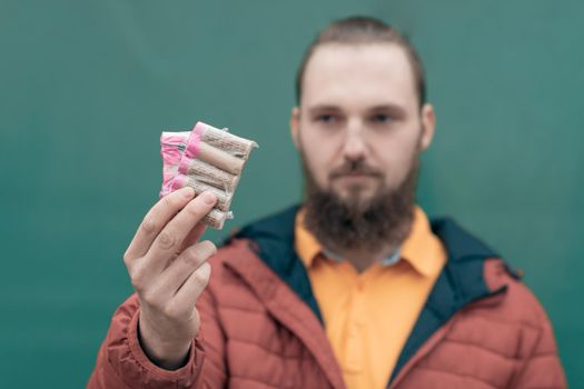 Serious Young Man Holding Firecrackers in his Hand. Bearded Guy Getting Ready for New Year Fun