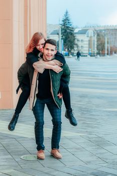 Cheerful Young Couple Hanging on the Street. Two Happy Loving People Having Fun Outdoors - Long Shot Portrait