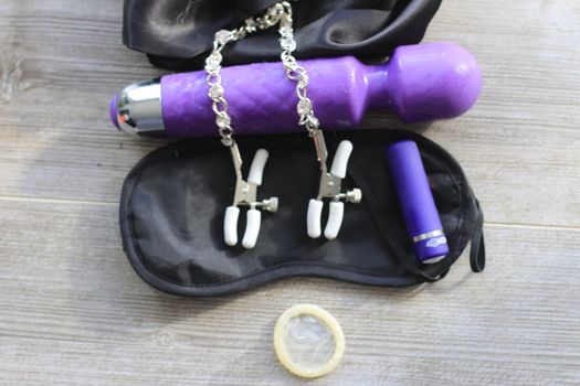 BDSM themed images showing a large dildo, nipple clamps, restraints, eye covers, and a condom. High quality photo