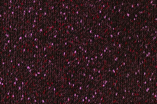 black melange manually knitted fabric with red and pink blotches - seamless texture and flat background.