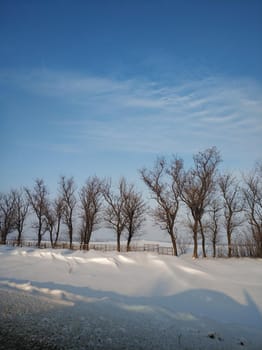 Winter landscape. A distant village in the cold part of the planet. White snow covered road.