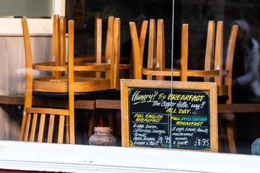 Chairs on the tables of a restaurant forced to close during lockdown to control COVID-19 pandemic, Cambridge, UK