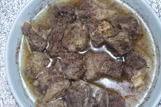 Top view of siri paaye or paya dish garnished with diced ginger, long coriander and black pepper. This dish is popular in Pakistan and Bangladesh