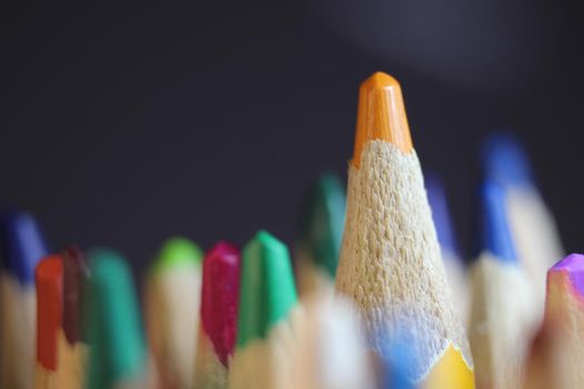 Close-up view of bright colored multicolor pencils on black background