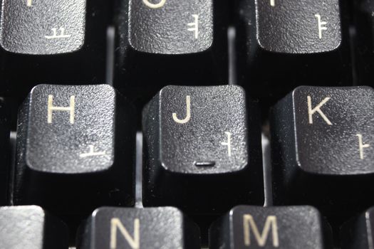 Closeup of laptop computer keyboard black keys with white letters and numbers. Black keys with white characters.