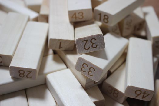 Pile of wooden blocks with engraved letters dispersed on floor. Children toy for building creative works.