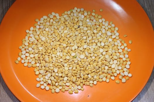 Yellow chickpea lentils seeds macro closeup view. Chana daal or yellow split peas spread background