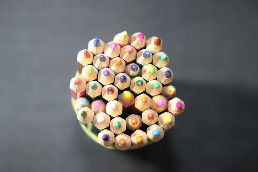 Close-up view of bright colored multicolor pencils on black background