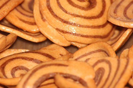 Closeup view with selective focus of a large number of round cookies with coconut filling lines.