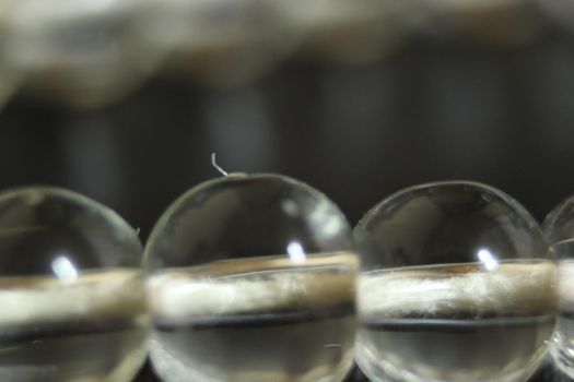 Macro photograph with selective focus of glass shiny prayer beads or rosary with copy space for text. Religion concept of ramadan or Eid for muslims.