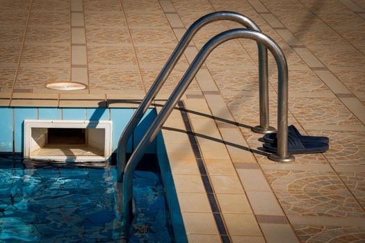 Closeup of swimming pool steps in the water under the sunlight at daytime