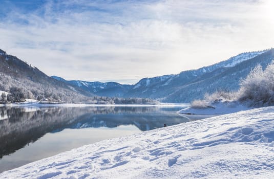 Idyllic winter landscape: Reflection lake, snowy trees and mountains