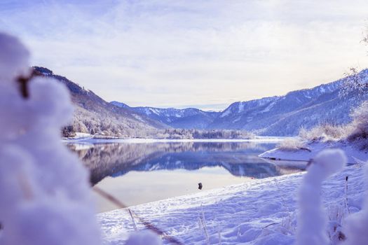 Idyllic winter landscape: Reflection lake, snowy trees and mountains