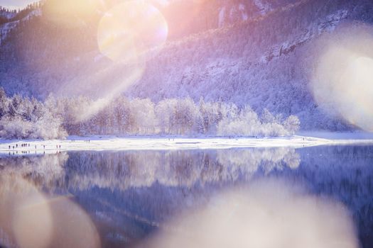 Idyllic winter landscape: Reflection lake, snowy trees and mountains