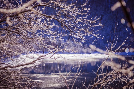 Idyllic winter landscape: Reflection lake, snowy trees and mountains