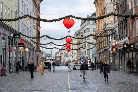 Copenhagen, Denmark - December 16, 2020: People walking on one of the main shopping strrets in the city centre, which is decorated for Christmas.