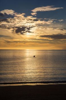 Silhouette of a kayak at sunrise in Abel Tasman National Park, New Zealand.