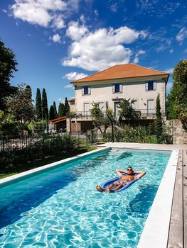 Guy relaxing in swimming pool during vacation in France, young man in swim pool chilling during summer in villa 