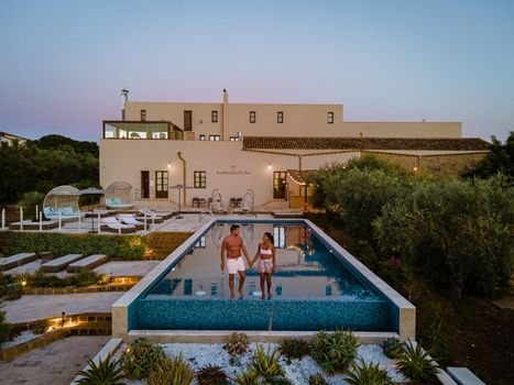 Luxury resort with a view over the wine field in Selinunte Sicily Italy. infinity pool with a view over wine fields in Sicilia, a couple on luxury vacation at the Island of Sicily Italy