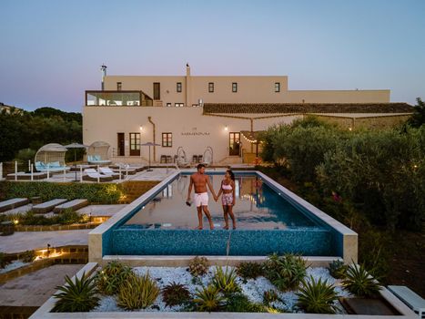 Luxury resort with a view over the wine field in Selinunte Sicily Italy. infinity pool with a view over wine fields in Sicilia, a couple on luxury vacation at the Island of Sicily Italy