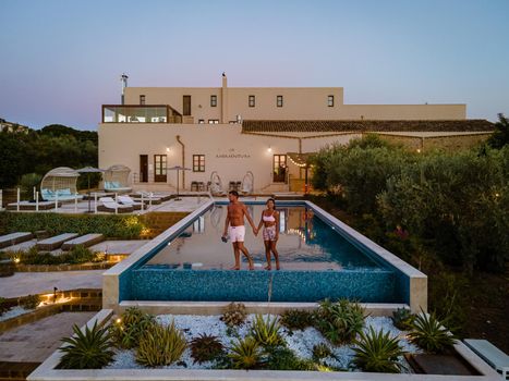 Luxury resort with a view over the wine field in Selinunte Sicily Italy. infinity pool with a view over wine fields in Sicilia, a couple on luxury vacation at the Island of Sicily Italy