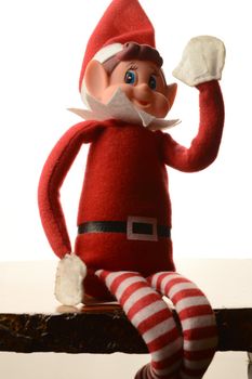 A closeup portrait of a Christmas Elf on a shelf over a white background.