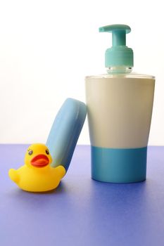 A bar of soap and liquid dispenser over a blue background remind us to wash our hands with a fresh clean feeling.
