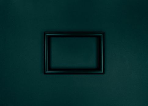 Frame on a wall, minimalistic green monochrome photo.