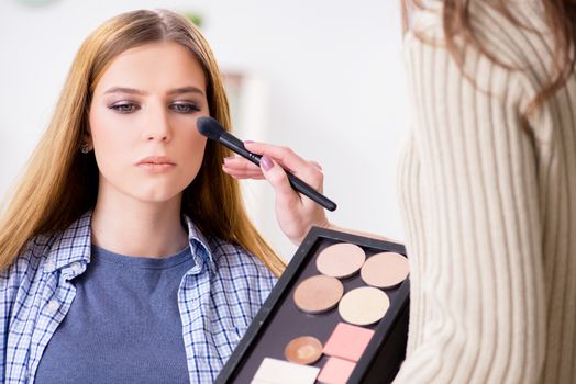 Woman getting her make-up done in beauty salon