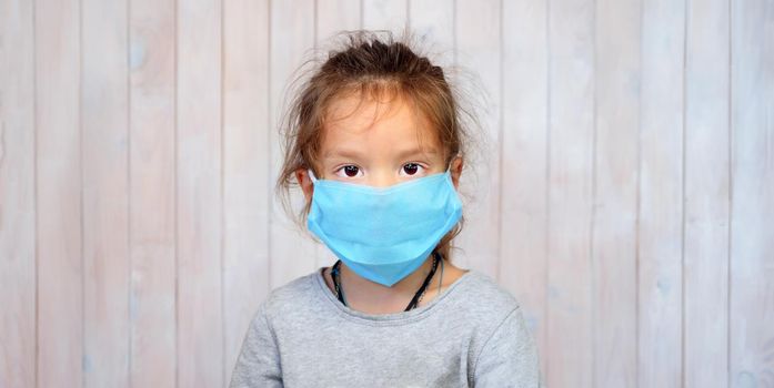 Children and Coronavirus. Child in a Mask. Portrait of Beautiful Girl in Medical Mask. Serious Face of a Small Kid. Five Years Old Girl Wearing Mask Looking at Camera. Adult Child in a Mask. Covid 19