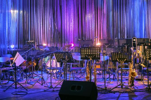 Musical Instruments and Equipment on Small Stage without People and Musicians. Concerts During Coronavirus Pandemic Covid-19. Illuminated Empty Stage for Orchestra. Online live Music. Online Event.