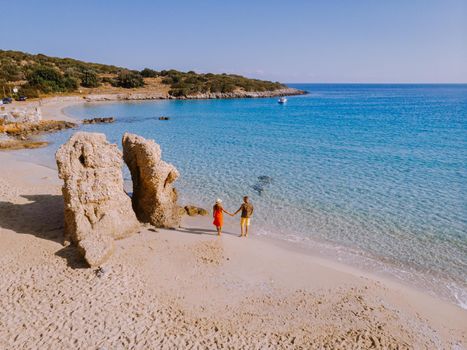 Tropical beach of Voulisma beach, Istron, Crete, Greece ,Most beautiful beaches of Crete island -Istron bay near Agios Nikolaos drone aerial view, couple walking on the ebach
