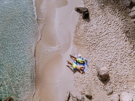 Tropical beach of Voulisma beach, Istron, Crete, Greece ,Most beautiful beaches of Crete island -Istron bay near Agios Nikolaos drone aerial view from above at the beach with people in swimsuit