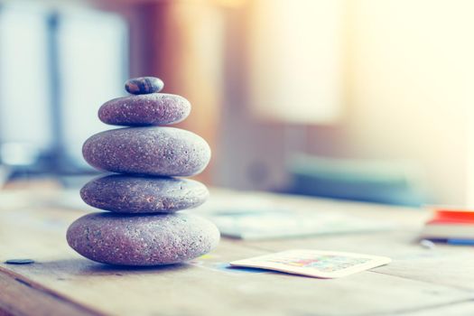 Feng Shui: Stone cairn in the foreground, blurry living room in the background. Balance and relaxation.